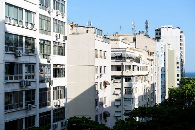 Vista lateral para o mar, rua tranquila e arborizada