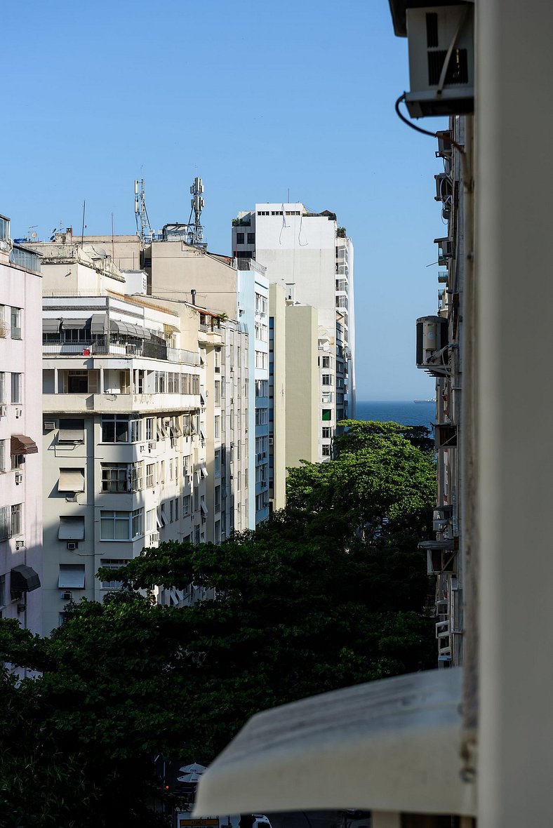 Vista lateral para o mar, rua tranquila e arborizada